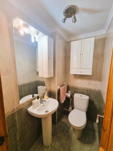 a bathroom with a white toilet and a sink at New Apartment Alejandro in Torre del Mar