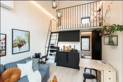 Una sala de estar con un sofá azul y una cocina. en KODA Edam, en Edam