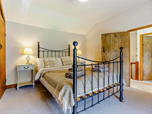a bedroom with a black bed with a wooden headboard at 4 Bed in Hereford 44213 in Hereford