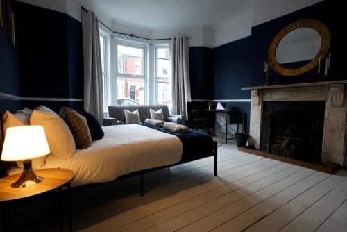 a bedroom with a bed with a fireplace and a mirror at Centrally Located Stylish Flat in Jesmond