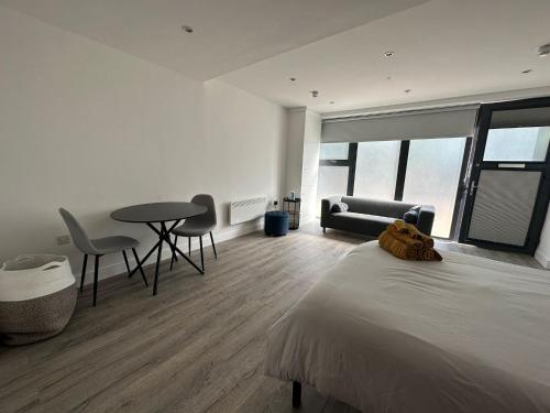 - une chambre avec un lit, une table et des chaises dans l'établissement Modern Studio Flat near Highbury & Islington station, à Londres
