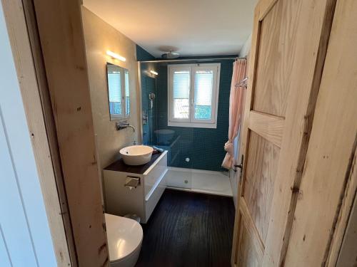 a bathroom with a sink and a toilet and a window at Chalet Friesli Beatenberg in Beatenberg