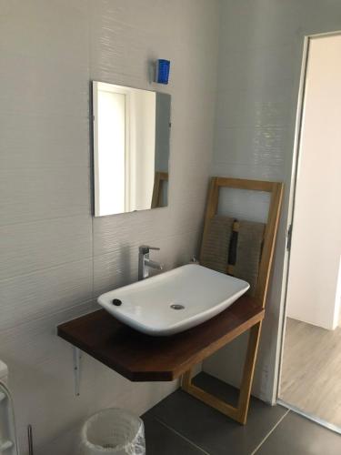 uma casa de banho com um lavatório branco e um espelho. em Baía Villa em São Tomé