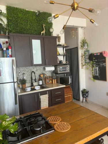 a kitchen with a table and a stove top oven at MI CASITA BOHO GREEN in Guayama