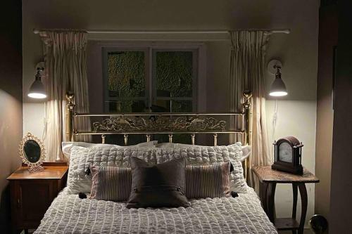 ein Schlafzimmer mit einem weißen Bett mit Kissen und einem Fenster in der Unterkunft Large 4 bed house in Malmesbury, great for big families in Malmesbury