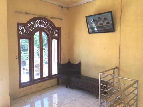 a room with a window and a bench in it at SPOT ON 93670 Homestay Vicky 2 Syariah in Sidoarjo