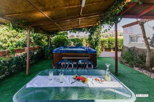 a table with two chairs and a pool in a yard at Avigail Guest House in Yavneʼel