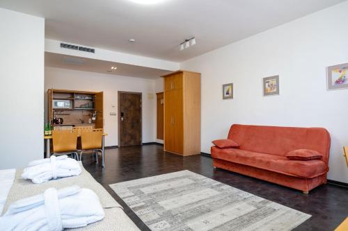 a living room with a red couch and a table at Hotel Galant Mikulov in Mikulov