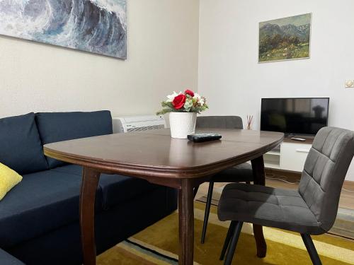 a living room with a table and a blue couch at Apartment Kiril and Metodi 41-8А in Berkovitsa