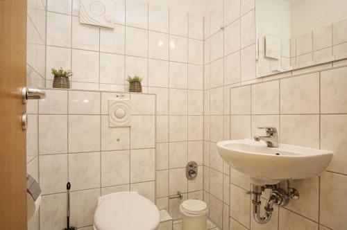 La salle de bains est pourvue d'un lavabo et de toilettes. dans l'établissement Hafenhäuser Breege FeWo 06 - Balkon, Meerblick, à Breege