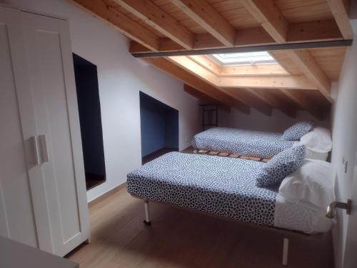 2 camas en una habitación con techo en Ocle, en Colunga