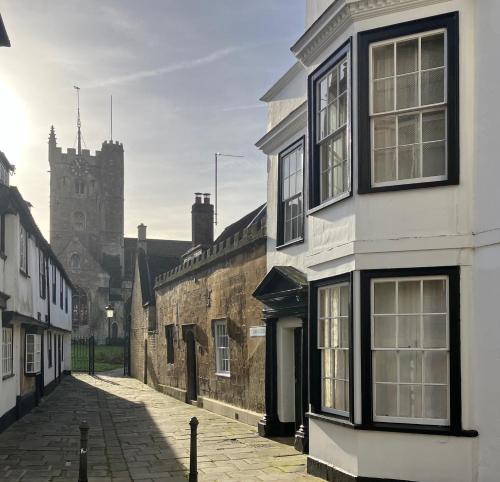 an alley with buildings and a church in the background at Bailey House in Devizes