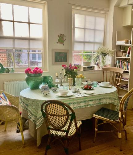 a dining room table with a green vase on it at Bailey House in Devizes