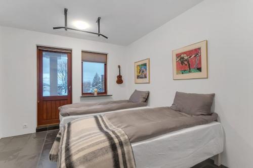 2 Betten in einem Zimmer mit 2 Fenstern in der Unterkunft Modern 3BR Oasis in Kópavogur in Reykjavík