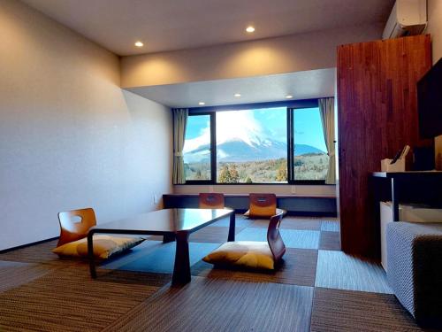 a room with a table and chairs and a window at Rokumeikan Hills in Yamanakako