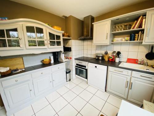 a kitchen with white cabinets and white appliances at Chez Manu in Rodez