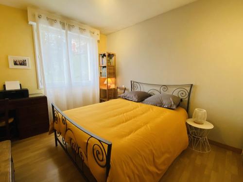 a bedroom with a large yellow bed with a window at Chez Manu in Rodez