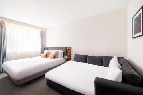 a hotel room with two beds and a couch at Holiday Inn Birmingham M6, Jct7 by IHG in Birmingham