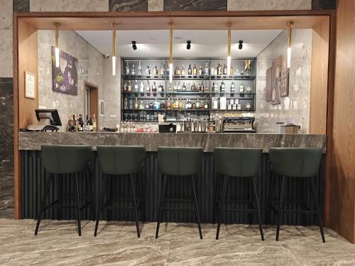 a bar with four green bar stools at Wyndham Garden Baku in Baku
