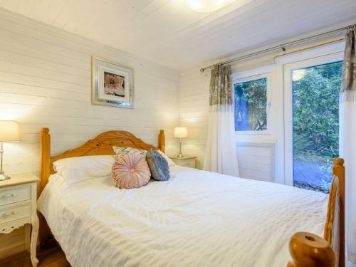 um quarto com uma cama branca e uma janela em 2 Bed in Machynlleth 86293 em Machynlleth
