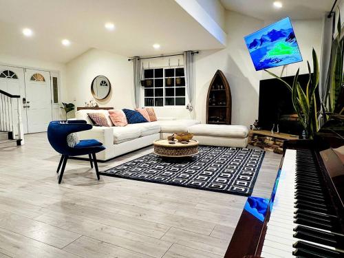 a living room with a white couch and a piano at Los Angeles Hideaway - Villa Costanso in Los Angeles
