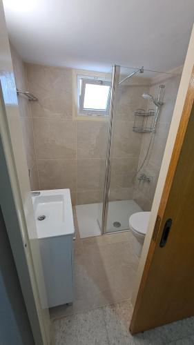 a bathroom with a shower and a toilet and a sink at Relaxing 2 Seaside Manors in Meneou