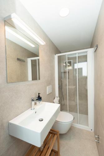 a bathroom with a white sink and a toilet at Alibi B11 in Piran