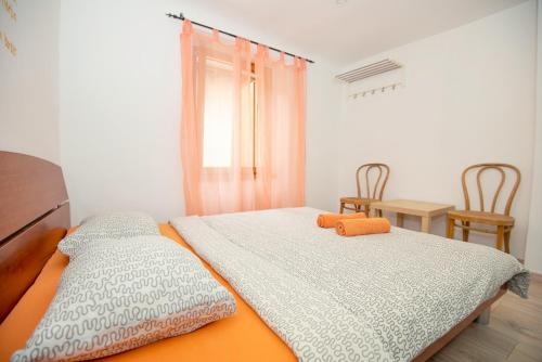 two beds in a room with a table and chairs at Alibi B11 in Piran