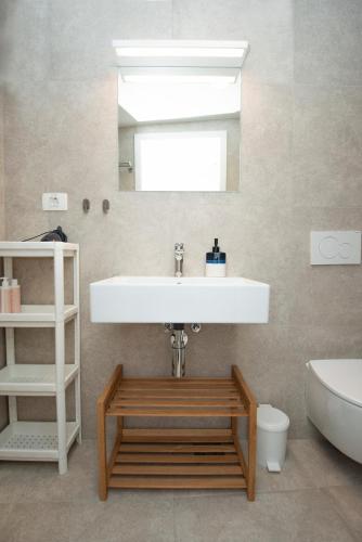 a bathroom with a sink and a toilet and a mirror at Alibi B11 in Piran