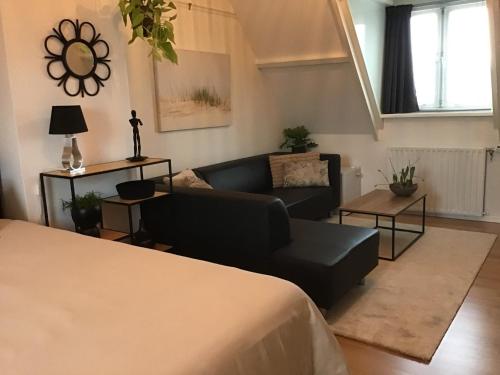 - un salon avec un canapé noir et un canapé dans l'établissement Sunny dunes, à Zandvoort