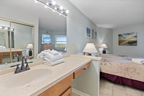 a bathroom with a sink and a bed at Perdido Sun Resort 704 By Pkrm in Pensacola