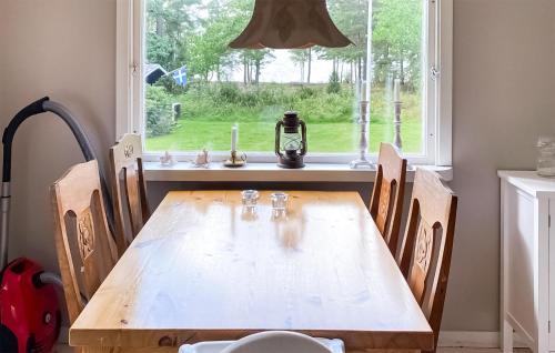 uma mesa de madeira com cadeiras em frente a uma janela em Stunning Home In Undens With House Sea View em Undenäs