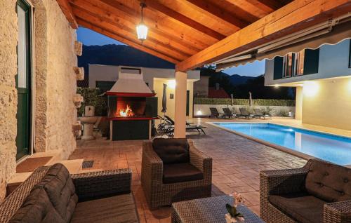 a patio with a fireplace and a swimming pool at Stunning Home In Sestanovac in Šestanovac