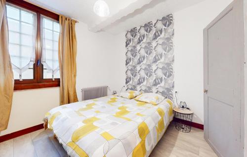 a bedroom with a bed with a yellow and white comforter at Cozy Home In Feuquires With Kitchen in Feuquières
