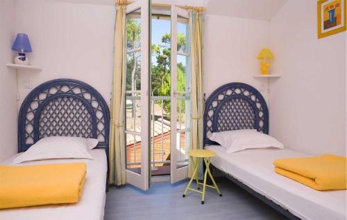 Plage-des-DemoisellesにあるLes Mas De Saint Hilaireの窓付きの部屋 ベッド2台