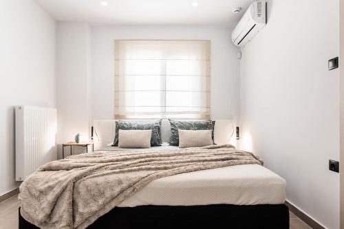 a bedroom with a large bed with a large window at Downtown Urban Luxurious Apartment in Athens