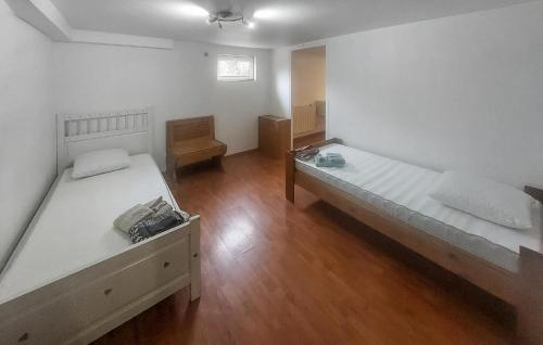 two beds in a room with wooden floors at Cozy Home In Le Vaumain With Kitchen in Le Vaumain