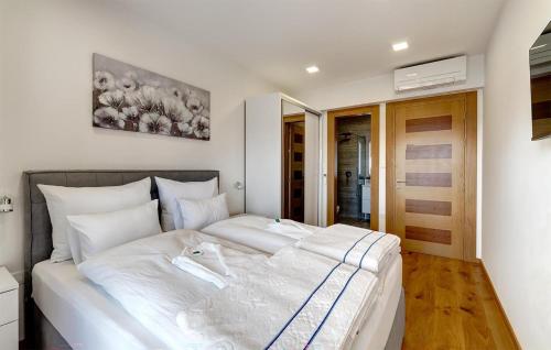 Schlafzimmer mit einem großen weißen Bett in der Unterkunft Cozy Home In Dramalj With House Sea View in Dramalj