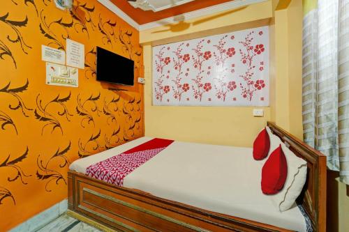 a small bedroom with a bed and a painting on the wall at OYO Flagship Hotel Dream Plaza in Aurangābād