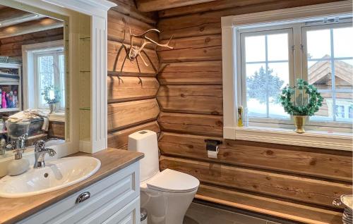 baño con paredes de madera, lavabo y aseo en Awesome Home In Reinli With Kitchen en Reinli