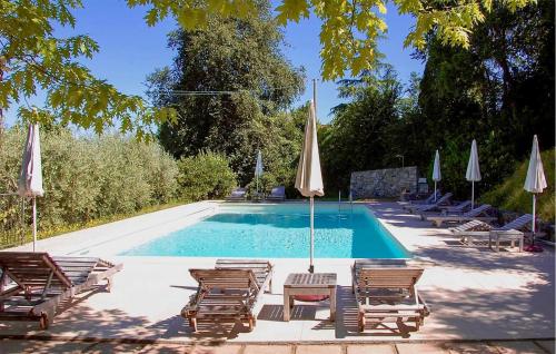 a swimming pool with lounge chairs and umbrellas at Stunning Home In Paciano With Kitchen in Paciano