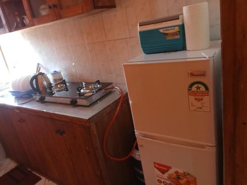 a kitchen with a microwave on top of a refrigerator at Magical Fharhana House in Malindi