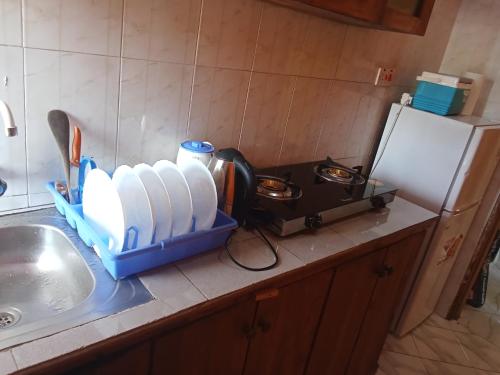 a kitchen counter with a sink and a container of water at Magical Fharhana House in Malindi