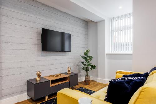a living room with a flat screen tv on a wall at Sea Breeze - Coast in Bournemouth