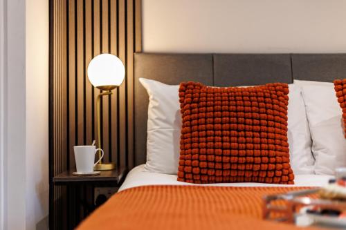 a bedroom with a bed with a red pillow on it at Sea Breeze - Coast in Bournemouth