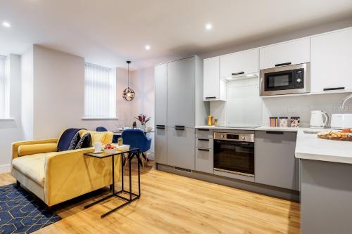 a living room with a couch and a kitchen at Sea Breeze - Coast in Bournemouth