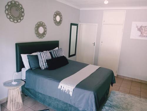 a bedroom with a large bed and a mirror at Be Our Guest Near OR TAMBO International Airport Room 2 in Boksburg