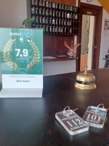 a table with a sign and two keys on it at Siris Hotel in Nova Siri Marina