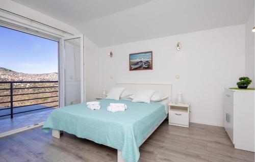 een witte slaapkamer met een bed en een balkon bij Stunning Apartment In Slime With House A Panoramic View in Slime
