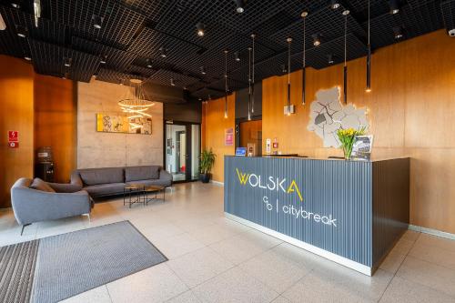 a lobby with couches and a reception desk in a building at City Break Wolska Aparthotel in Warsaw